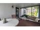 A sunroom with views of the yard, featuring a round table, chairs, a wooden bench, and a side table at 5808 13Th Street E Ct, Bradenton, FL 34203