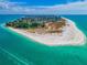 Stunning aerial view of a coastal community surrounded by crystal clear turquoise waters and white sandy beaches at 609 Foxworth Ln, Holmes Beach, FL 34217