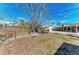 Large fenced backyard space with green grass and a few mature trees at 609 Foxworth Ln, Holmes Beach, FL 34217