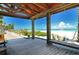View from a covered area over looking a gorgeous white sand beach on a sunny day with calm water and blue sky at 609 Foxworth Ln, Holmes Beach, FL 34217