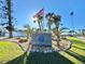 Key Royale entrance featuring palm trees, lawn and the American flag at 609 Foxworth Ln, Holmes Beach, FL 34217