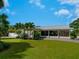 Beautiful single-story home featuring lush landscaping, palm trees, and a well-manicured lawn at 609 Foxworth Ln, Holmes Beach, FL 34217