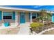 Charming home featuring a lovely front entrance, vibrant landscaping, and a welcoming blue door at 609 Foxworth Ln, Holmes Beach, FL 34217