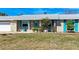 Charming home featuring turquoise shutters, a well-kept lawn and a stylish exterior at 609 Foxworth Ln, Holmes Beach, FL 34217