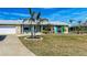 Beautiful single-story home with a manicured lawn and coastal landscaping accents at 609 Foxworth Ln, Holmes Beach, FL 34217