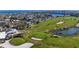 Scenic view of a lush green golf course nestled within a residential area and waterfront, complete with sand traps and a pond at 609 Foxworth Ln, Holmes Beach, FL 34217