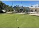 Scenic golf course putting green featuring flags and lush landscaping near the clubhouse with outdoor seating at 609 Foxworth Ln, Holmes Beach, FL 34217