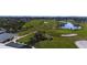 Aerial view of a meticulously maintained golf course with green fairways, sand traps, and a tranquil pond in a beautiful landscape at 609 Foxworth Ln, Holmes Beach, FL 34217