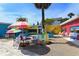 Charming outdoor seating area with colorful furniture and a vibrant peacock mural, creating a lively atmosphere at 609 Foxworth Ln, Holmes Beach, FL 34217