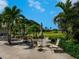 Charming outdoor patio area with tables and chairs overlooking the lush green golf course at 609 Foxworth Ln, Holmes Beach, FL 34217