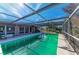 Screened-in pool area with lush landscaping and a bright blue sky at 609 Foxworth Ln, Holmes Beach, FL 34217