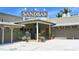 Welcoming entrance to Sandbar, featuring a rustic wooden sign, plants, and a glimpse of the interior at 609 Foxworth Ln, Holmes Beach, FL 34217