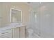 Bathroom featuring a walk-in shower, framed mirror with vanity lighting, and white cabinets at 656 Tropical Cir, Sarasota, FL 34242