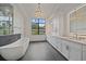 Elegant bathroom features a soaking tub, dual vanities, and a large window for natural light at 656 Tropical Cir, Sarasota, FL 34242