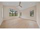 Sunlit bedroom with neutral tones, vaulted ceilings, and large windows offers ample natural light at 656 Tropical Cir, Sarasota, FL 34242