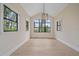 Bright dining room with vaulted ceiling, modern chandelier, and picturesque windows offering serene views at 656 Tropical Cir, Sarasota, FL 34242