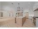 Open-concept kitchen boasts stainless steel appliances, white cabinets, wood island with quartz countertop, and hardwood flooring at 656 Tropical Cir, Sarasota, FL 34242