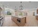 Open-concept kitchen with a large island, modern appliances, and light wood floors offers a bright and airy space at 656 Tropical Cir, Sarasota, FL 34242