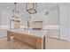 Luxurious kitchen featuring pendant lighting, white cabinets, stainless steel appliances, and a large wood island with quartz countertop at 656 Tropical Cir, Sarasota, FL 34242