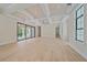 Spacious living room with coffered ceilings, light wood floors, and large sliding glass doors to lanai at 656 Tropical Cir, Sarasota, FL 34242