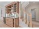 Custom wet bar featuring glass shelving, wine storage, a beverage refrigerator, and staircase access at 656 Tropical Cir, Sarasota, FL 34242