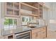 Elegant wet bar with custom cabinetry, a beverage cooler, and stylish mirrored backsplash at 656 Tropical Cir, Sarasota, FL 34242