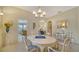 Bright dining area with a white table, chairs, and large chandelier at 92 Tall Trees Ct, Sarasota, FL 34232
