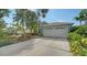Beautiful home featuring a wide driveway leading to a two-car garage, complemented by lush landscaping at 92 Tall Trees Ct, Sarasota, FL 34232