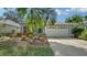 Charming home featuring a two-car garage, vibrant landscaping, and a well-manicured front yard at 92 Tall Trees Ct, Sarasota, FL 34232