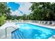 Enjoy the community pool on a warm summer day, surrounded by lush landscaping and comfortable lounge chairs at 92 Tall Trees Ct, Sarasota, FL 34232