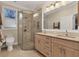 Bright bathroom featuring dual sinks, granite countertops, tiled floors, and glass-enclosed shower at 1359 Tearose Pl, Sarasota, FL 34239