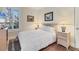 Well-lit bedroom with a queen bed, wooden nightstands, lamps, and large windows with plantation shutters at 1359 Tearose Pl, Sarasota, FL 34239