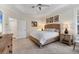 Bright bedroom featuring a king bed, stylish lamps, neutral paint, and an ensuite bathroom at 1359 Tearose Pl, Sarasota, FL 34239