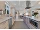 Modern kitchen featuring a large island, stainless steel appliances, and convenient microwave and oven at 1359 Tearose Pl, Sarasota, FL 34239