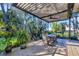 Outdoor screened-in lanai with a dining area and plenty of greenery in the background, promoting outdoor living at 1359 Tearose Pl, Sarasota, FL 34239