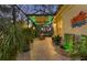 Outdoor patio featuring lush greenery, a water fountain, and a covered dining area with green LED lighting for evening enjoyment at 1359 Tearose Pl, Sarasota, FL 34239