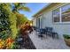 Charming outdoor patio with a table and chairs, surrounded by lush landscaping, perfect for dining at 1359 Tearose Pl, Sarasota, FL 34239