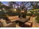 Enjoy the evening ambiance on this screened-in patio with outdoor lighting and comfortable seating amid lush tropical landscaping at 1359 Tearose Pl, Sarasota, FL 34239