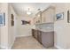 This wet bar features white cabinets, a sink, granite countertops, and a mini fridge, perfect for entertaining guests at 1359 Tearose Pl, Sarasota, FL 34239