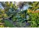 View of tropical yard with a stone statue head at 1359 Tearose Pl, Sarasota, FL 34239