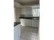 Bright kitchen with white cabinetry, a stainless steel sink, and tile flooring at 1873 University Pl # 135, Sarasota, FL 34235