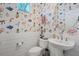 Charming powder room features whimsical flamingo wallpaper, pedestal sink, and wainscoting at 2006 Red Lake Run, Bradenton, FL 34211