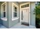 Charming front door with sidelight and transom window, complemented by the light blue exterior at 2006 Red Lake Run, Bradenton, FL 34211