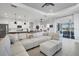 Bright and airy living room featuring an expansive white sectional, modern lighting, and sliding doors to outdoor patio at 2006 Red Lake Run, Bradenton, FL 34211