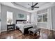 Serene bedroom with tray ceiling, hardwood floors, and ample natural light from large windows at 2006 Red Lake Run, Bradenton, FL 34211