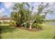 Landscaped backyard featuring mature trees and a swing overlooking the water at 273 Portofino Dr, North Venice, FL 34275