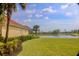 Well-maintained lawn and landscaped garden with a view of the lake at 273 Portofino Dr, North Venice, FL 34275