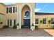 Stunning home featuring a unique arched entryway, blue double doors, and a well-manicured landscape at 273 Portofino Dr, North Venice, FL 34275