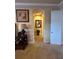 Hallway with arched entryway, neutral walls, art, and carpeted floor leading to the rest of the home at 273 Portofino Dr, North Venice, FL 34275