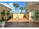 Private patio features a tiered fountain, manicured shrubbery, and brick paver flooring at 273 Portofino Dr, North Venice, FL 34275